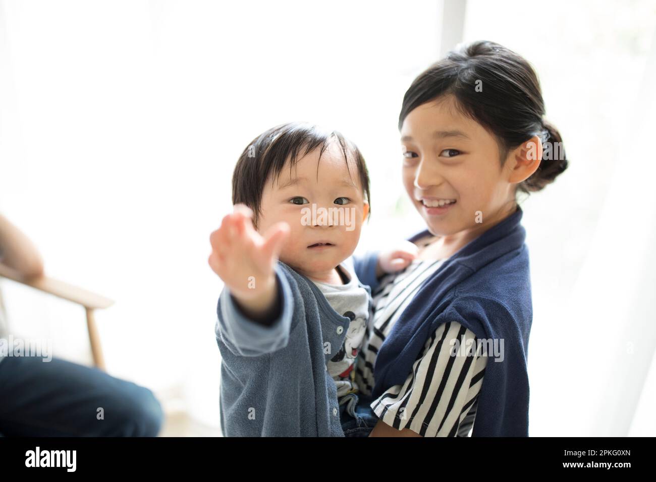 Ragazza della scuola elementare che tiene il fratello del bambino Foto Stock