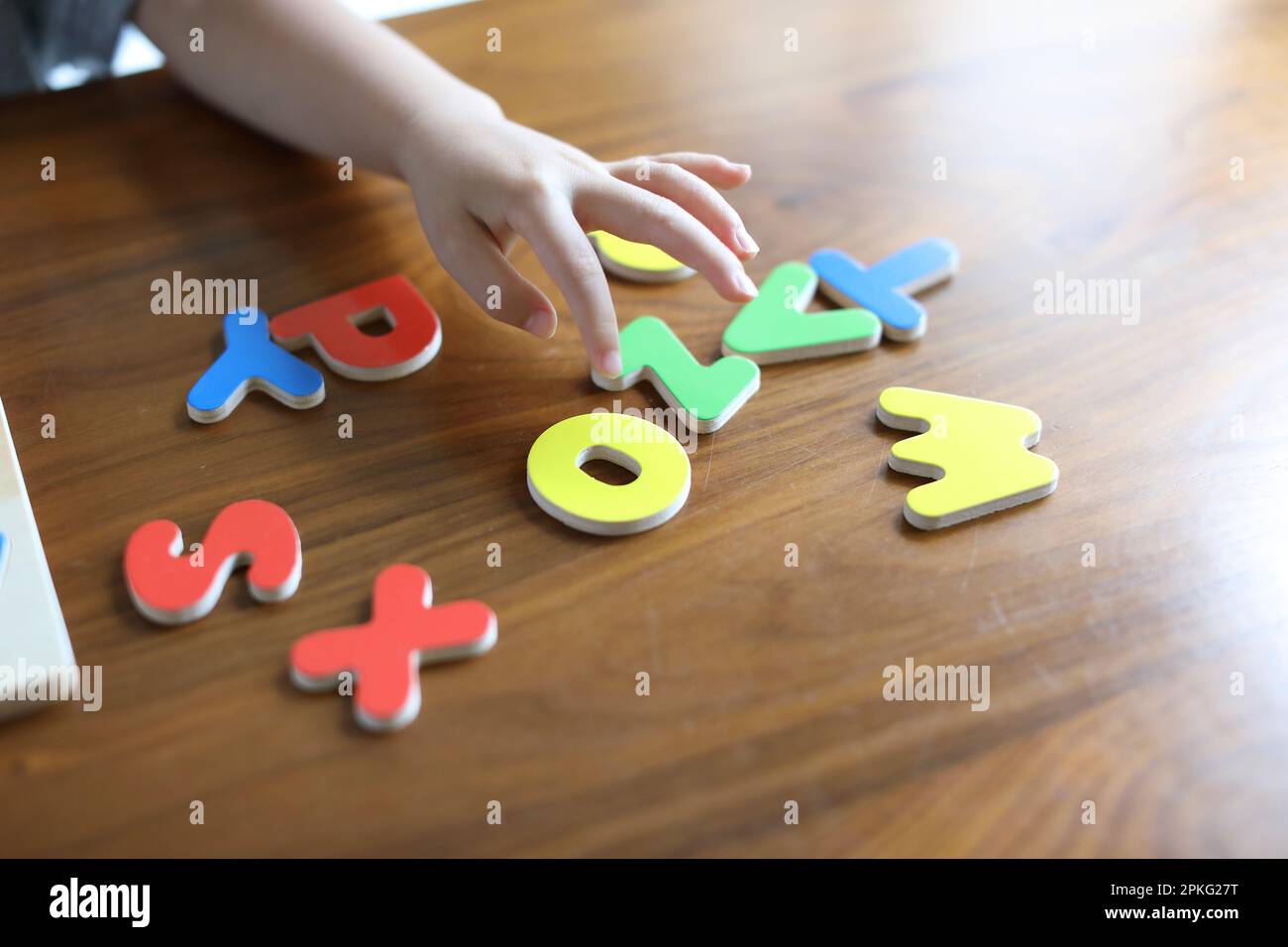 Le mani del bambino con il puzzle dell'alfabeto Foto Stock