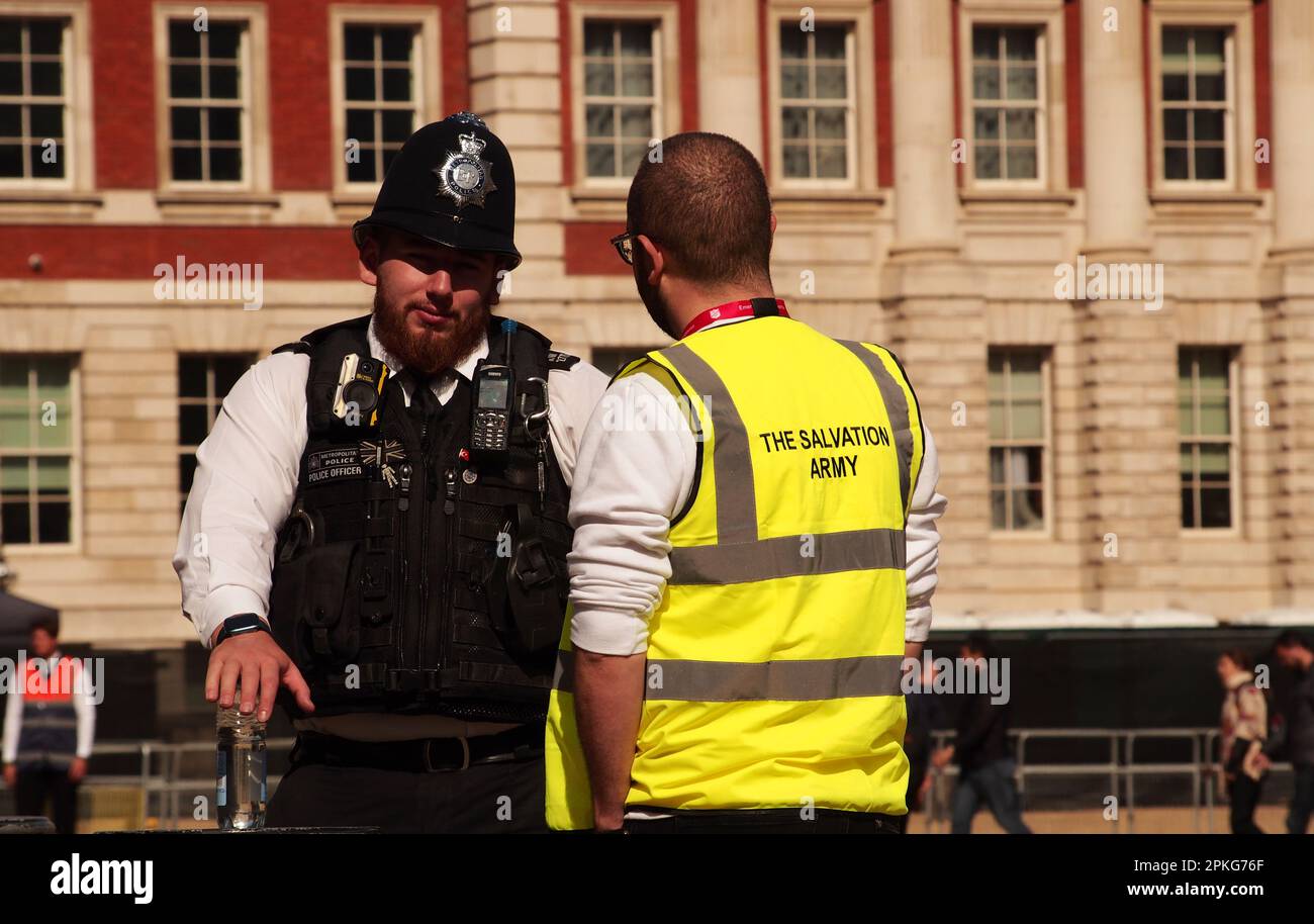 Una polizia metropolitana che parla con un uomo dell'Esercito di Salavtion nella parata horseguards, Londra, Inghilterra. REGNO UNITO Foto Stock