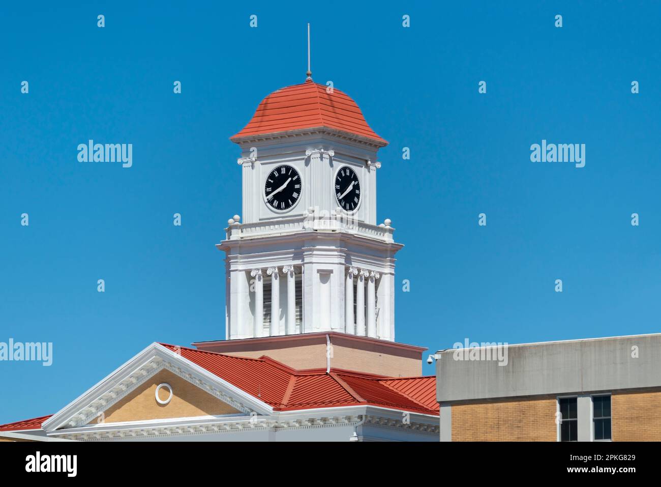 Ripresa orizzontale di una piccola e graziosa torre dell'orologio sotto un cielo azzurro con spazio per le copie. Foto Stock Ripresa orizzontale di una piccola e graziosa torre dell'orologio sotto un cielo azzurro con spazio per le copie. Foto Stock