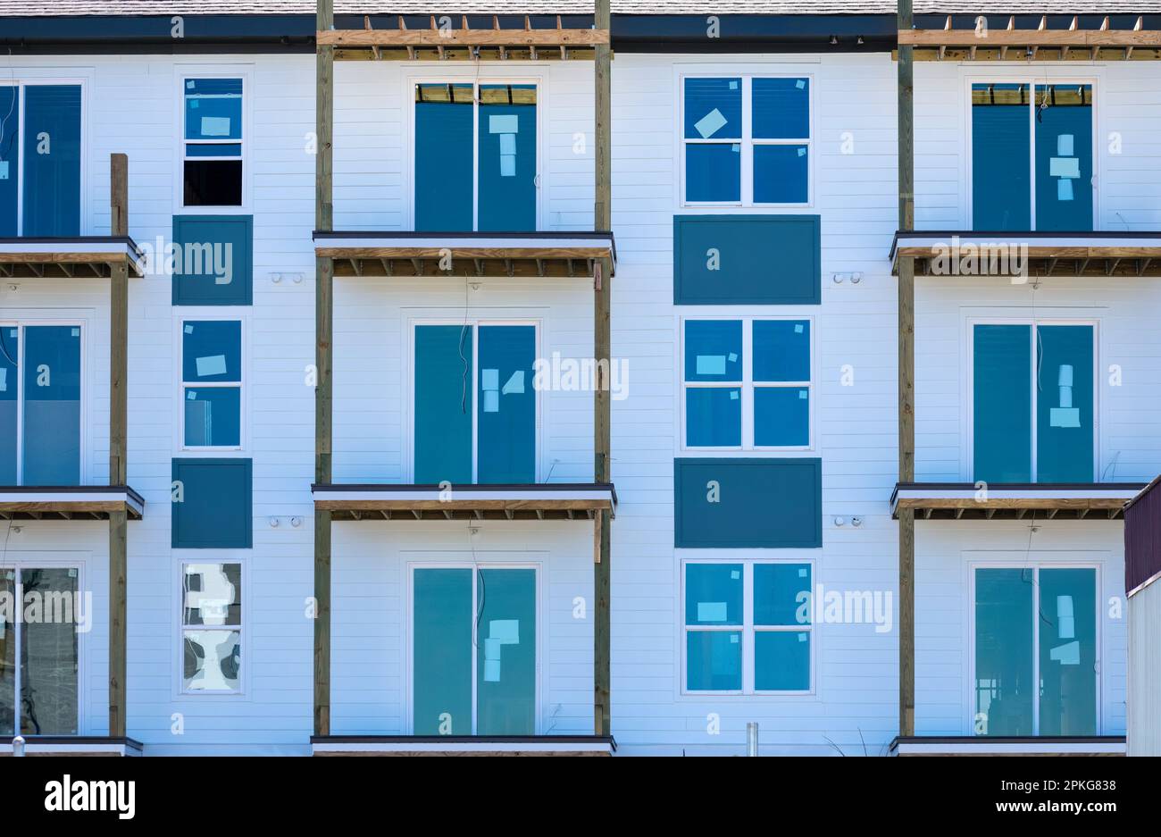 Immagine orizzontale di un edificio di appartamenti a più piani in costruzione in un quartiere fiorente. Foto Stock