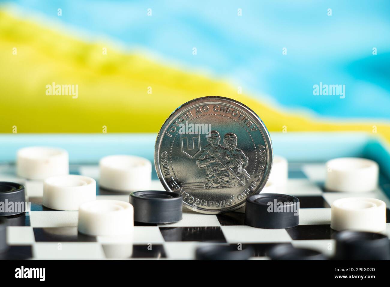 Moneta 10 hryvnia 2022 forze di difesa territoriale delle forze armate dell'Ucraina giacciono sugli ispettori e dietro come sfondo la bandiera dell'Ucraina Foto Stock