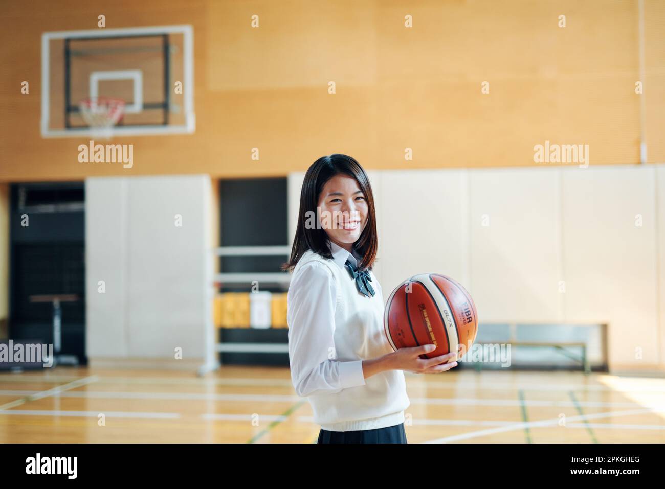 Ragazze delle scuole superiori che giocano a basket in palestra Foto Stock