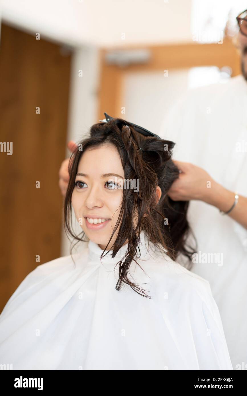 Donna che ha i capelli impostati da un estetista Foto Stock