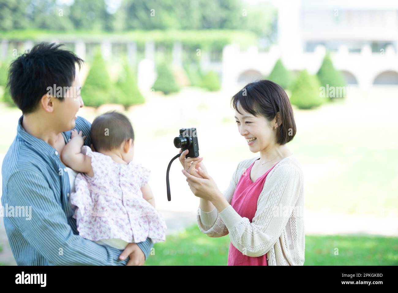 Madre scattando una foto dei suoi figli nel parco Foto Stock