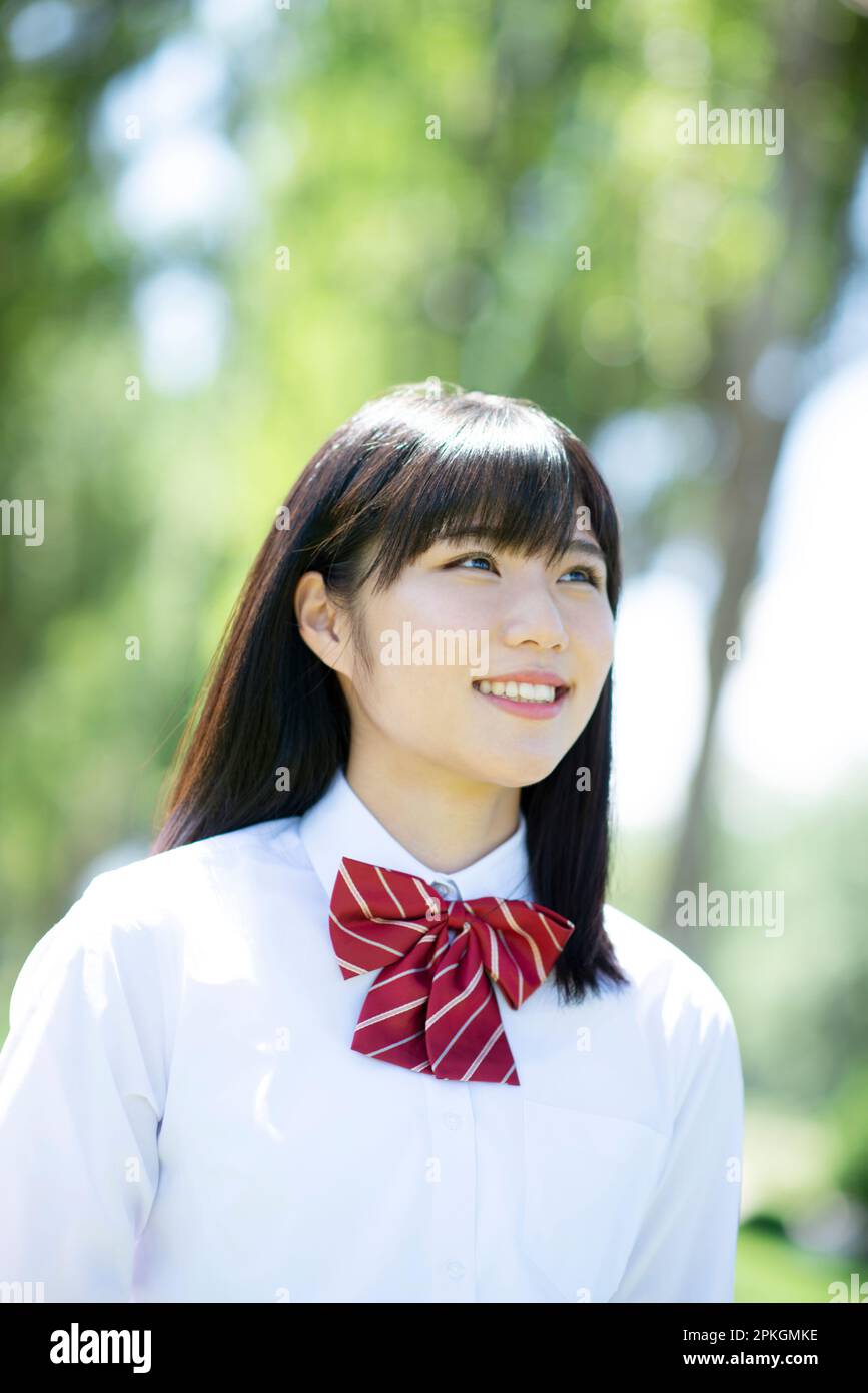 Studentessa sorridente ad una fila di alberi di pioppo Foto Stock