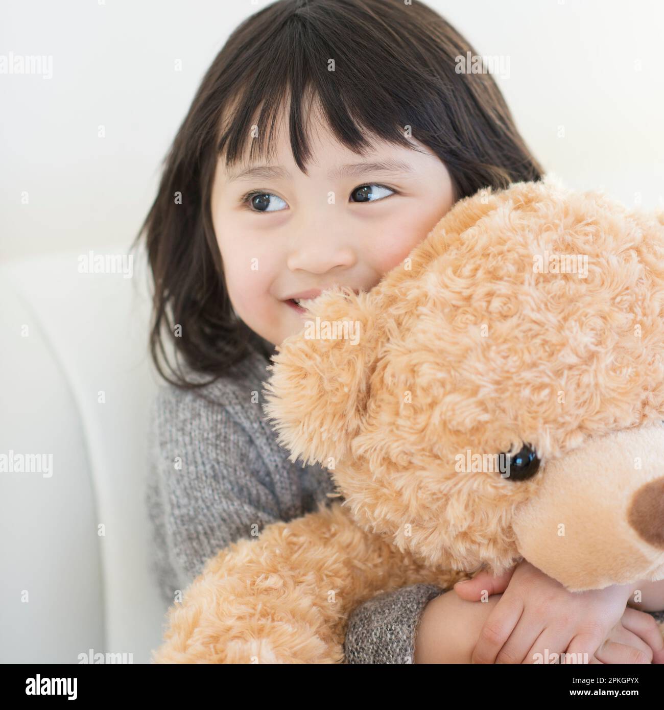 Ragazza sorridente con orso farcito Foto Stock