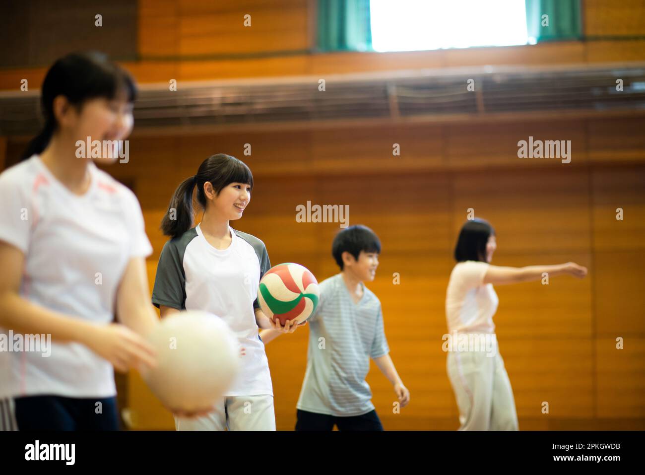 Gli studenti si allenano a pallavolo in palestra Foto Stock