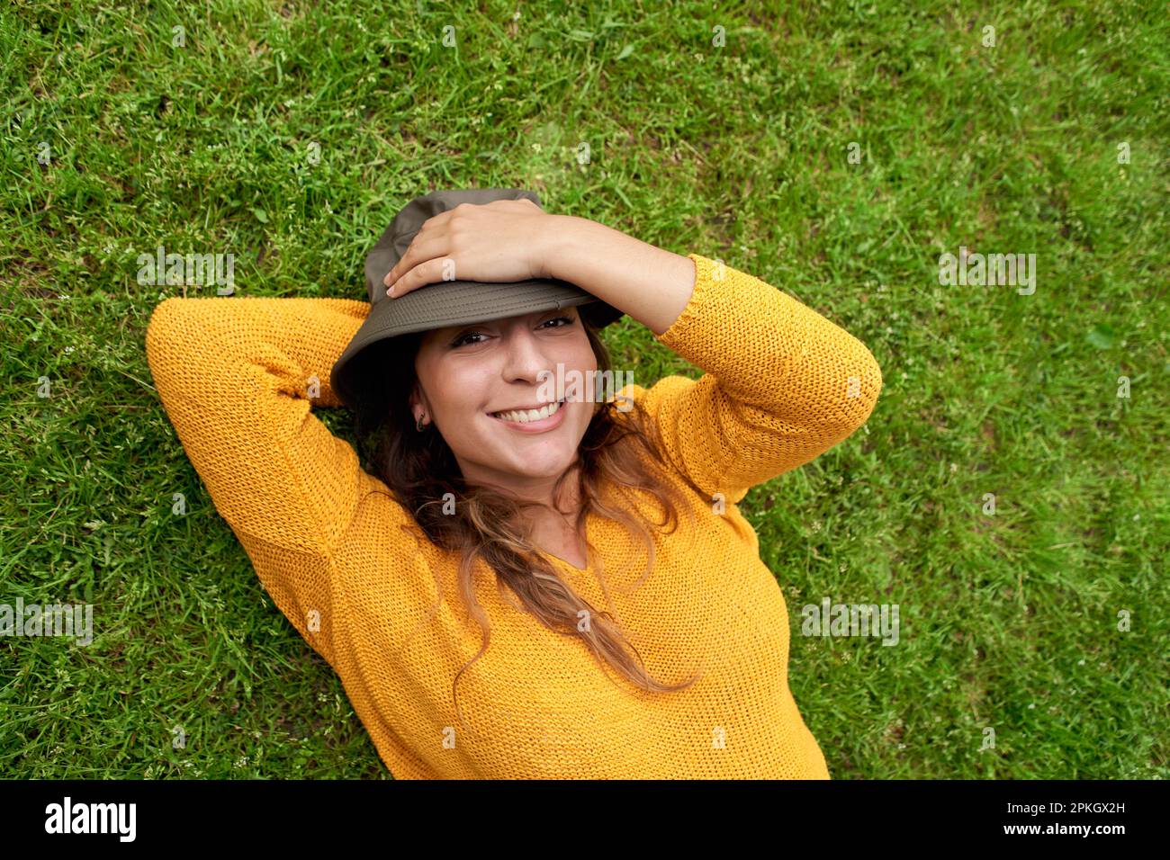 Donna sorridente sdraiati sull'erba Foto Stock