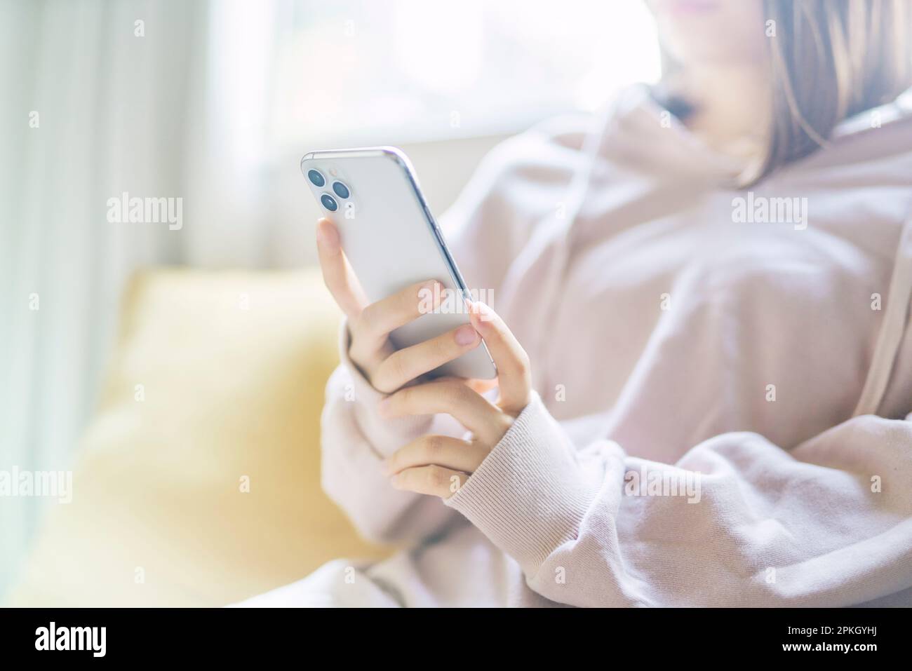 Donna in loungewear tenendo smartphone Foto Stock