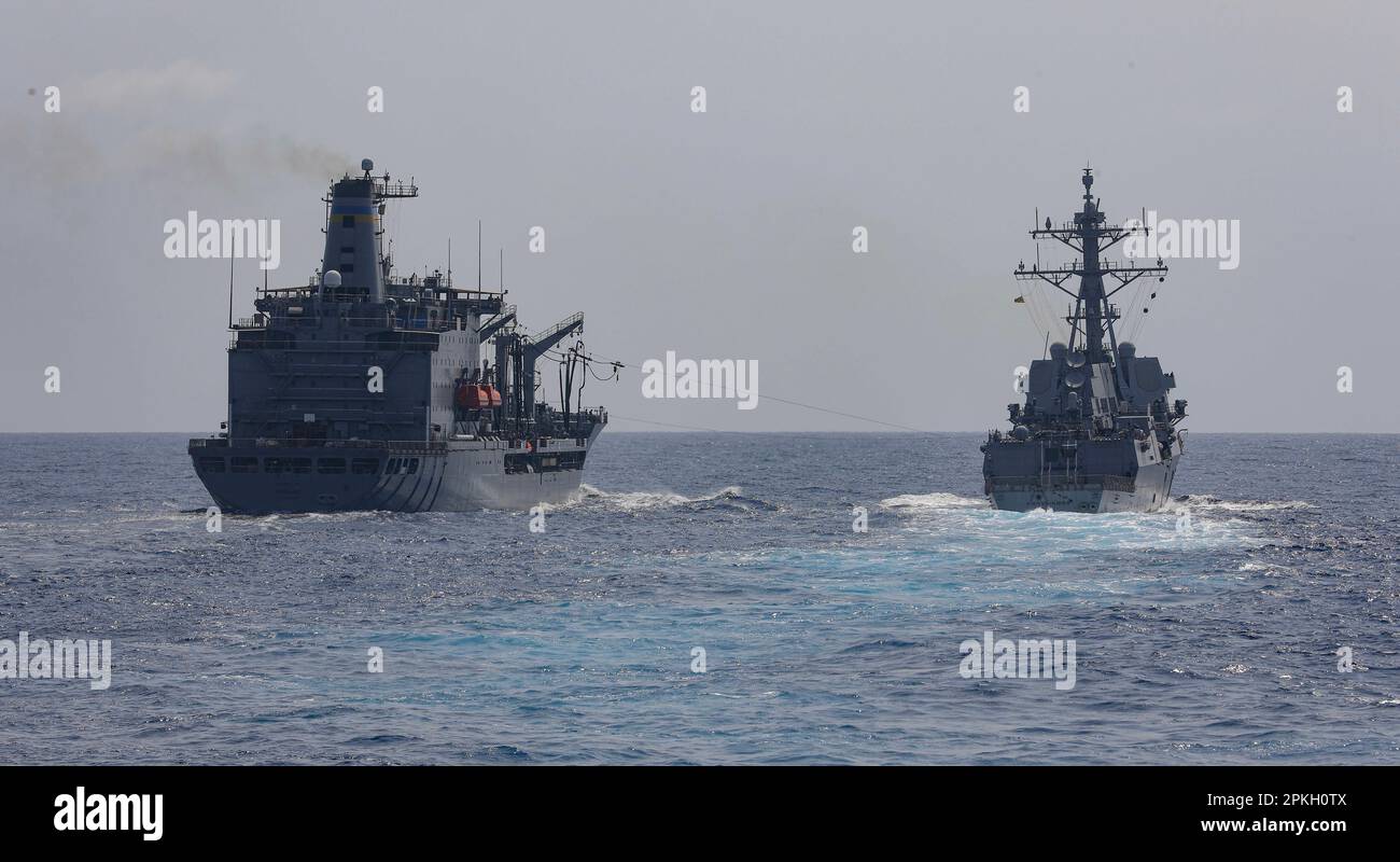 MARE DELLA CINA DEL SUD (6 aprile 2023) – l'oliatore di rifornimento della flotta di classe Henry J. Kaiser USNS Tippecanoe (T-AO 199), a sinistra, si incunea lungo il cacciatorpediniere missilistico guidato di classe Arleigh Burke USS Chung-Hoon (DDG 93) durante un rifornimento in corso mentre opera nel Mar della Cina del Sud, 6 aprile. Milius è assegnato al Comandante, Task Force 71/Destroyer Squadron (DESRON) 15, il più grande DESRON schierato in avanti della Marina e la principale forza di superficie della flotta degli Stati Uniti 7th. (STATI UNITI Foto Navy di Mass Communication Specialist 1st Class Greg Johnson) Foto Stock