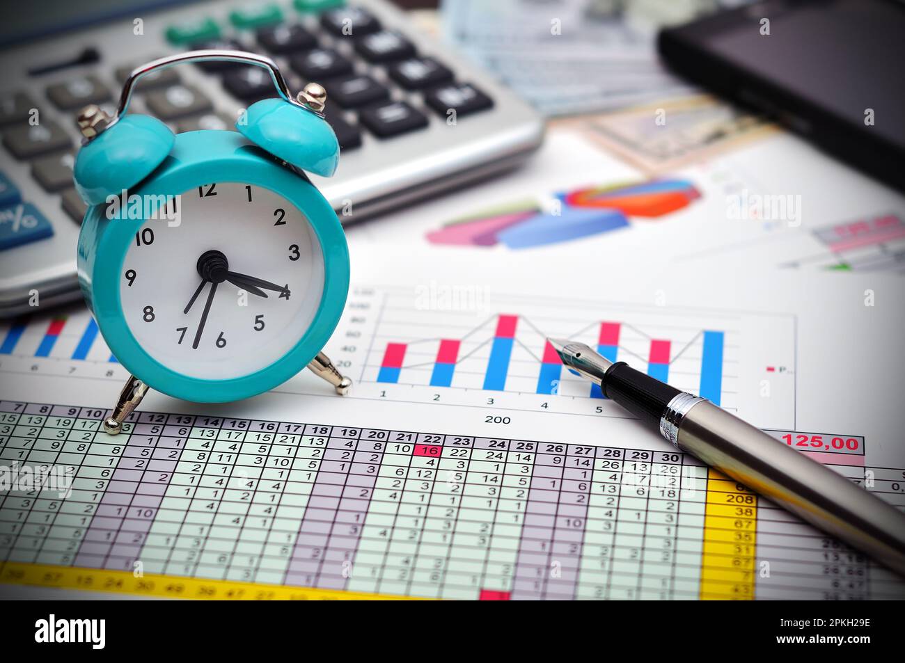 Penna stilografica,telefono, calcolatrice e orologio sul banco da lavoro Foto Stock