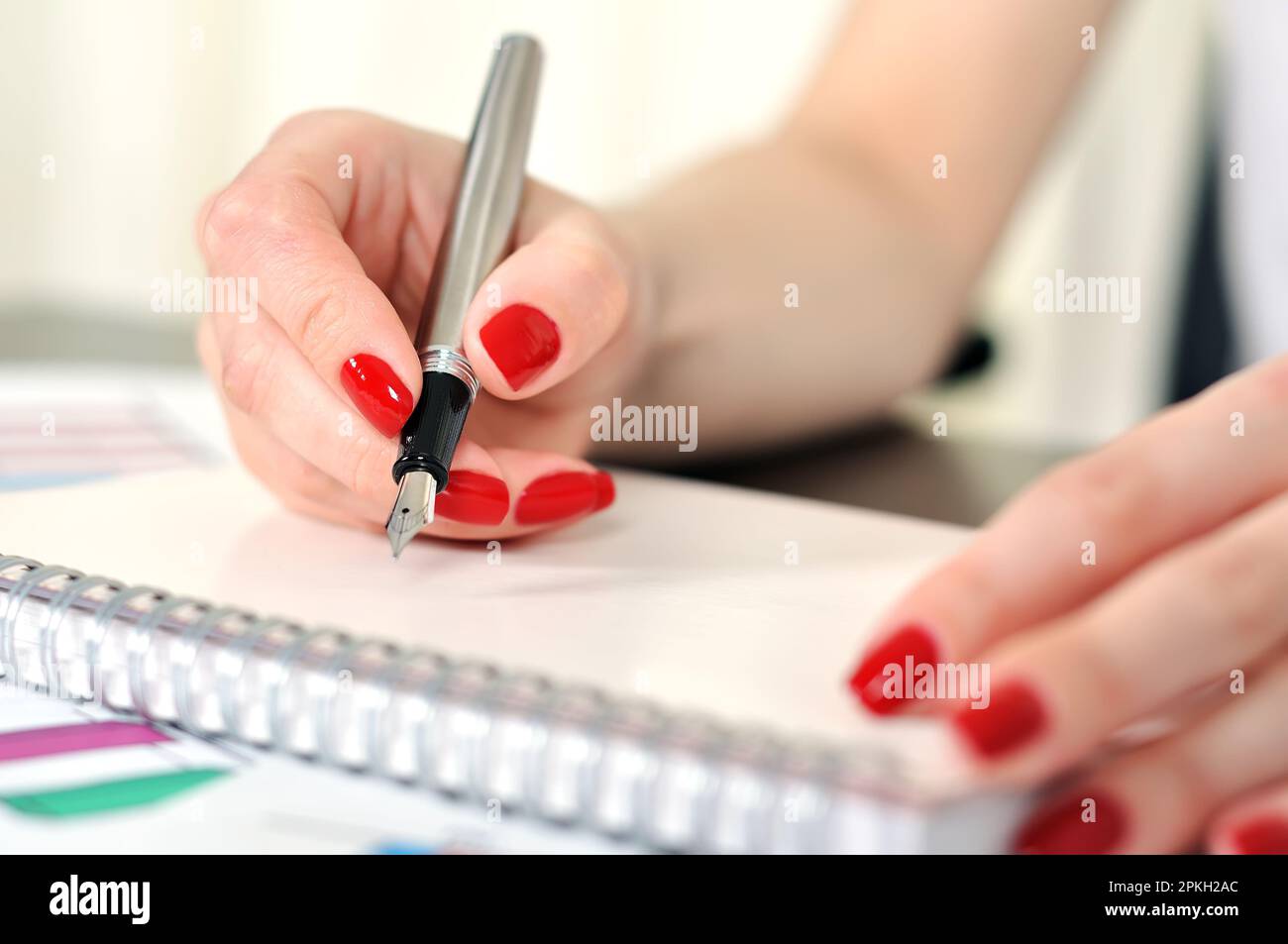 Mano con penna stilografica scrivendo su un notebook Foto stock - Alamy