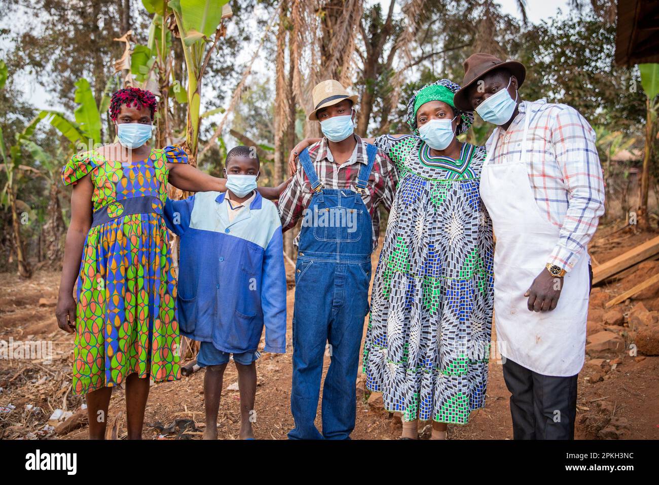 Un gruppo di africani nel villaggio indossare maschere chirurgiche per proteggersi dal coronavirus Foto Stock