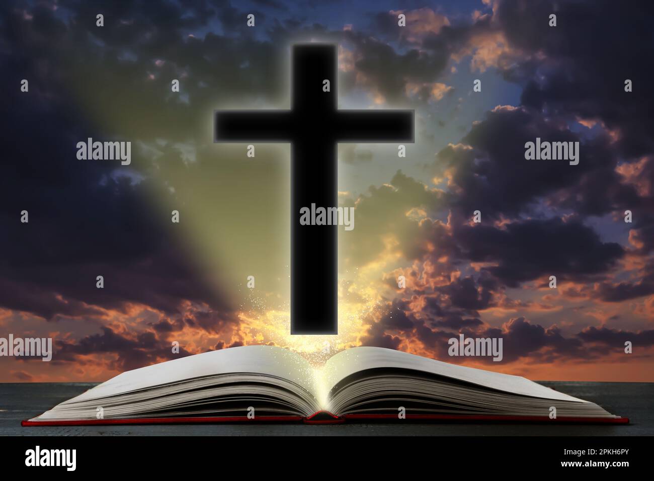 Silhouette di croce e Bibbia aperta su tavola contro cielo nuvoloso Foto Stock