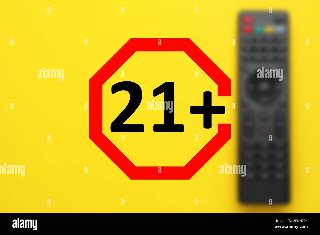 Segno del limite di età superiore a 21 anni e vista sfocata del telecomando su sfondo giallo Foto Stock