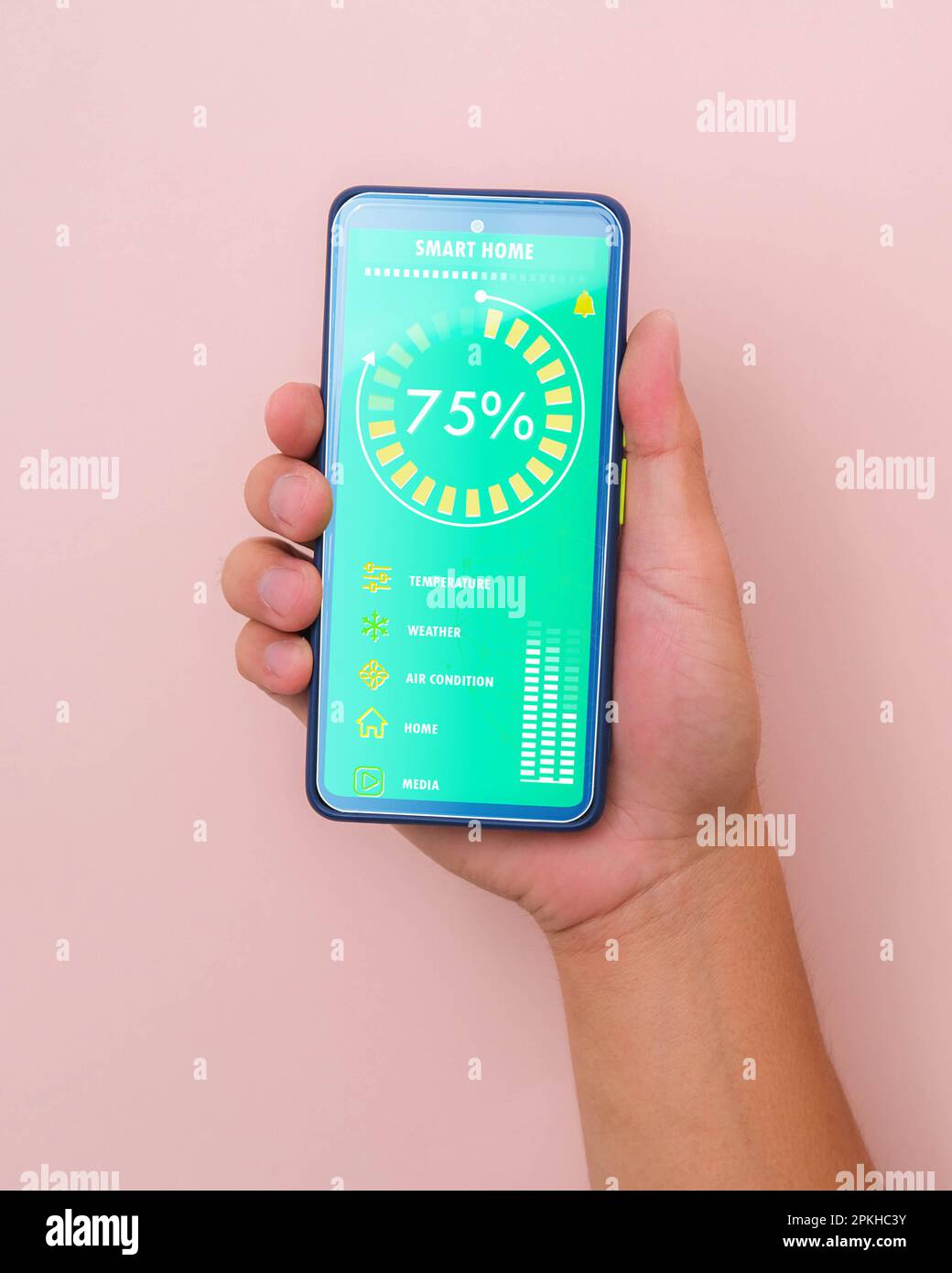 Mano maschile che tiene lo smartphone su sfondo rosa con l'interfaccia della tecnologia Smart Home sullo schermo dell'app per smartphone. Concetto di automazione. Foto Stock