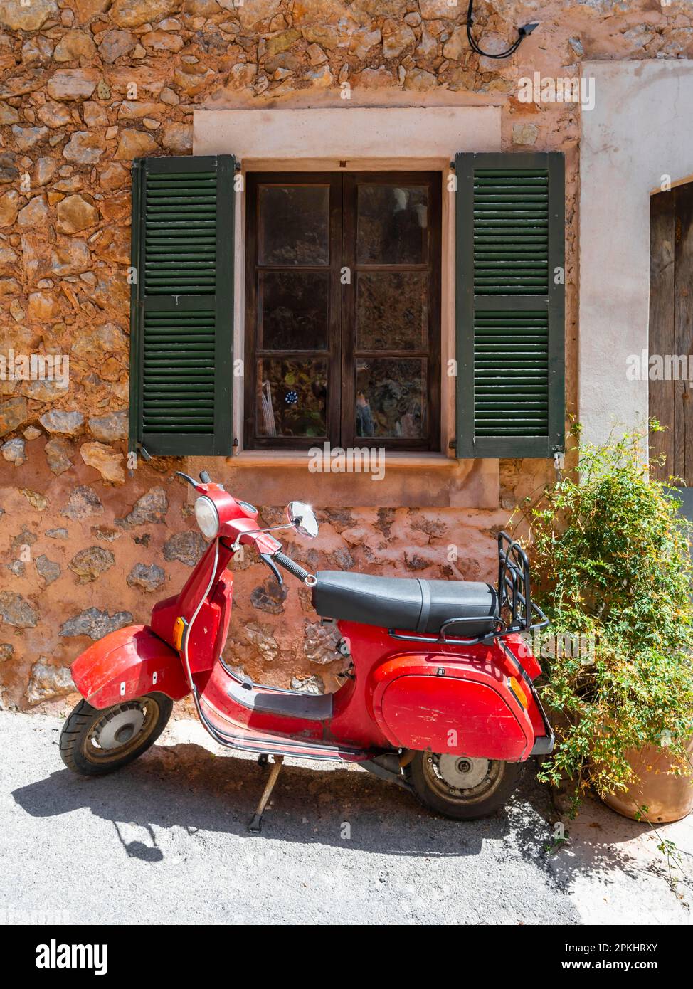 Vespa rossa di fronte alla finestra di una tipica casa in pietra, Deia,  Serra de Tramuntana, Maiorca, Isole Baleari, Spagna Foto stock - Alamy