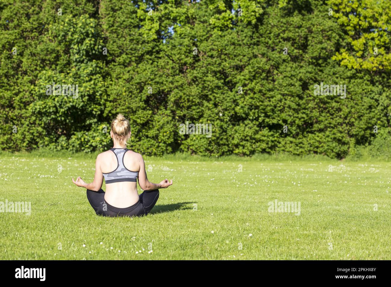 Donna (38) fare yoga in un prato nel parco, Kiel, Schleswig-Holstein, Germania Foto Stock