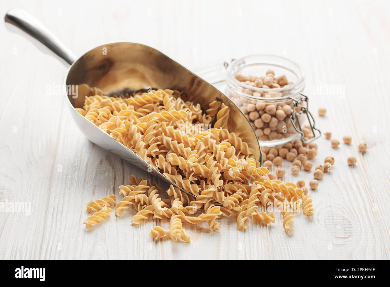 Fusilli di ceci su fondo ligneo. Tritare con pasta cruda e ceci. Pasta senza glutine. Foto Stock