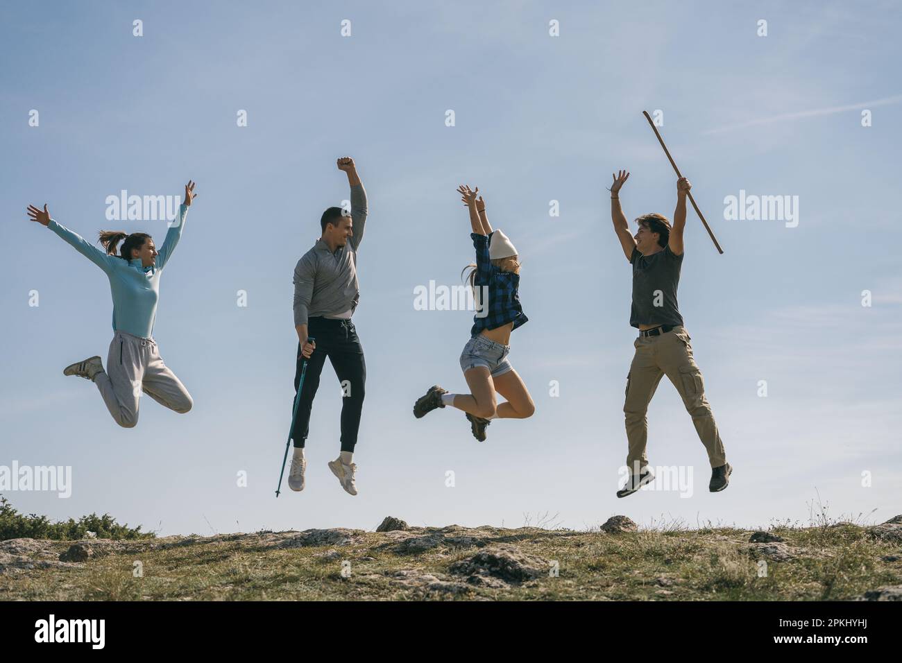 Giovani escursionisti in cima alla montagna divertirsi. Sono felici e saltano Foto Stock