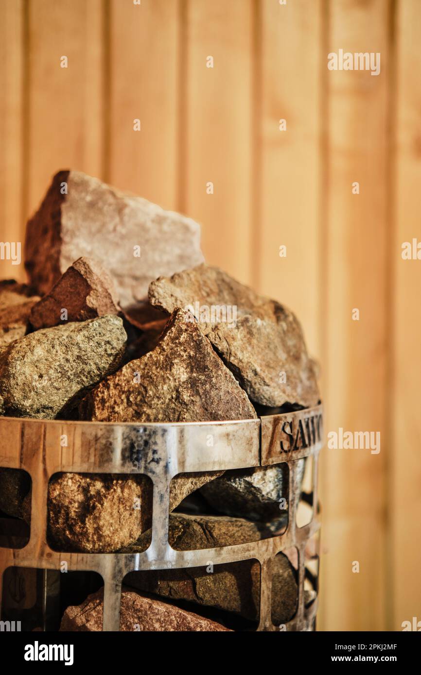 Vista in primo piano di rocce e pietre nella gabbia in sauna riscaldatore (foto con profondità di campo bassa) Foto Stock