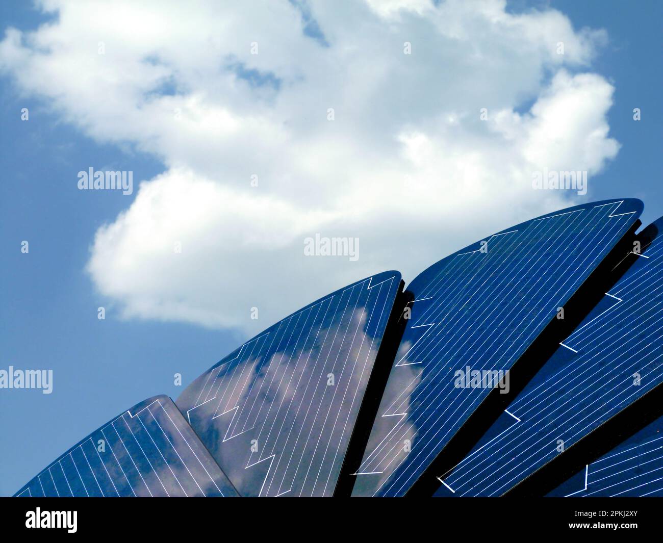 Pannello fotovoltaico solare a forma di fiore rotante e rotante per seguire il movimento del sole, ottenendo un tasso di efficienza più elevato. luce brillante e cielo estivo blu Foto Stock