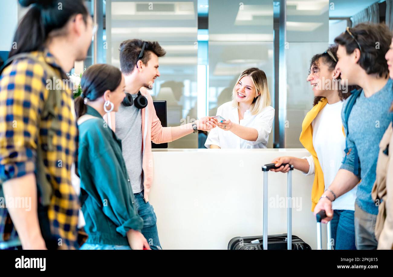 Giovani amici milleniali divertirsi alla reception dell'hotel al momento del check-in - concetto di stile di vita di viaggio con persone felici in attesa alla pensione d Foto Stock