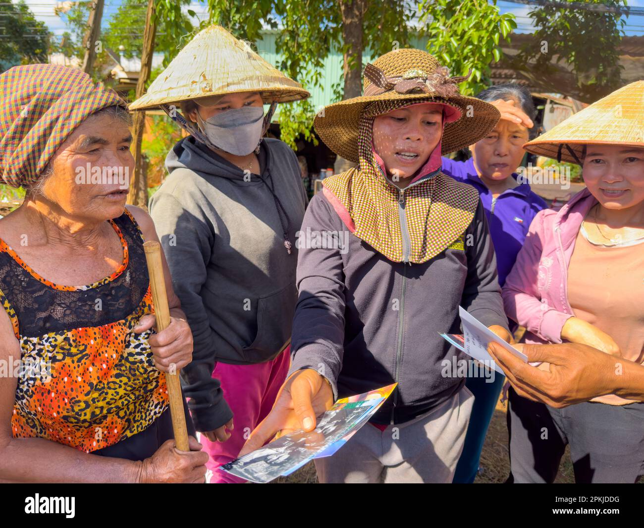 Cinque donne di minoranza etnica Jerai nel villaggio di Ia Pia, distretto di Chu prong, provincia di Gia Lai, Vietnam, guardare le vecchie fotografie insieme. Foto Stock