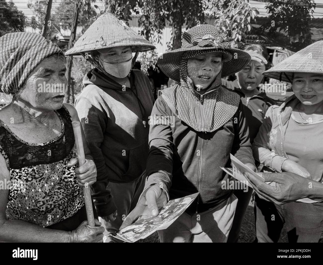 Cinque donne di minoranza etnica Jerai nel villaggio di Ia Pia, distretto di Chu prong, provincia di Gia Lai, Vietnam, guardare le vecchie fotografie insieme. Foto Stock