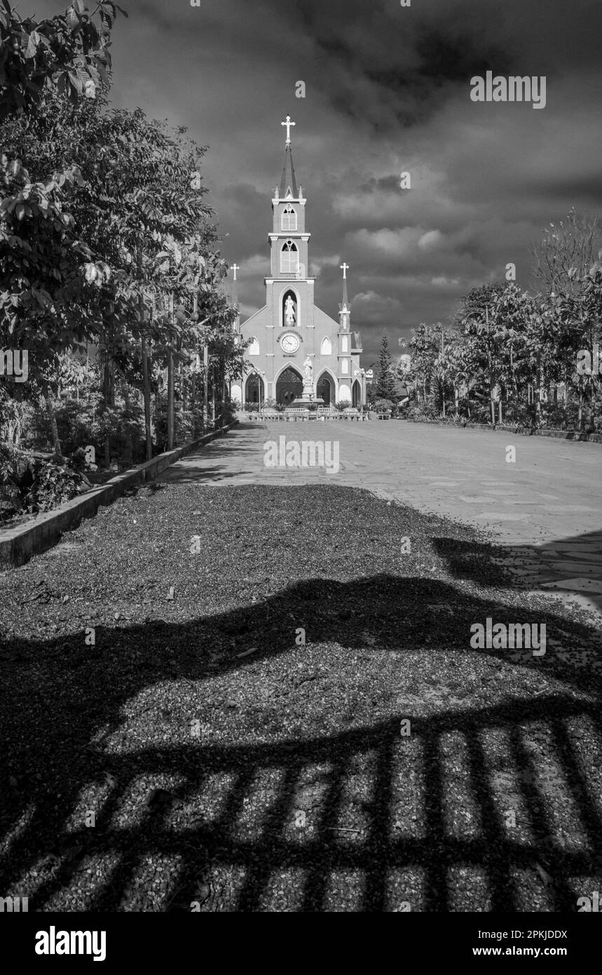 Le ciliegie di caffè appena raccolte si asciugano sul vialetto di accesso della Chiesa cattolica di Hoang Yen a Chu Prong, provincia di Gia Lai, Vietnam. Foto Stock