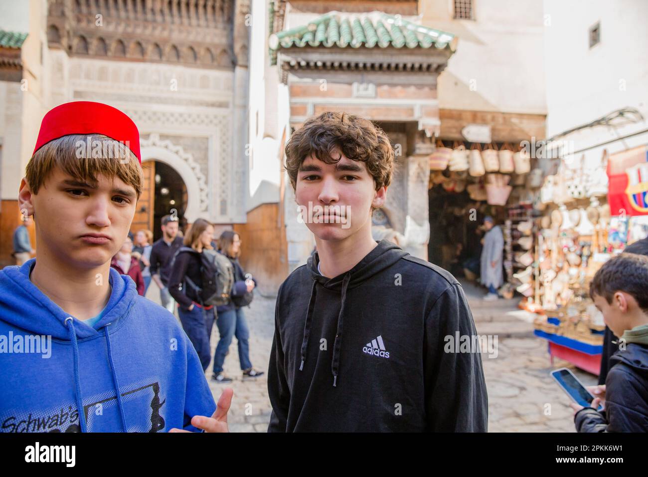 I fratelli americani si trovano all'esterno di una grande porta ad arco a Fez Medina Marocco Foto Stock