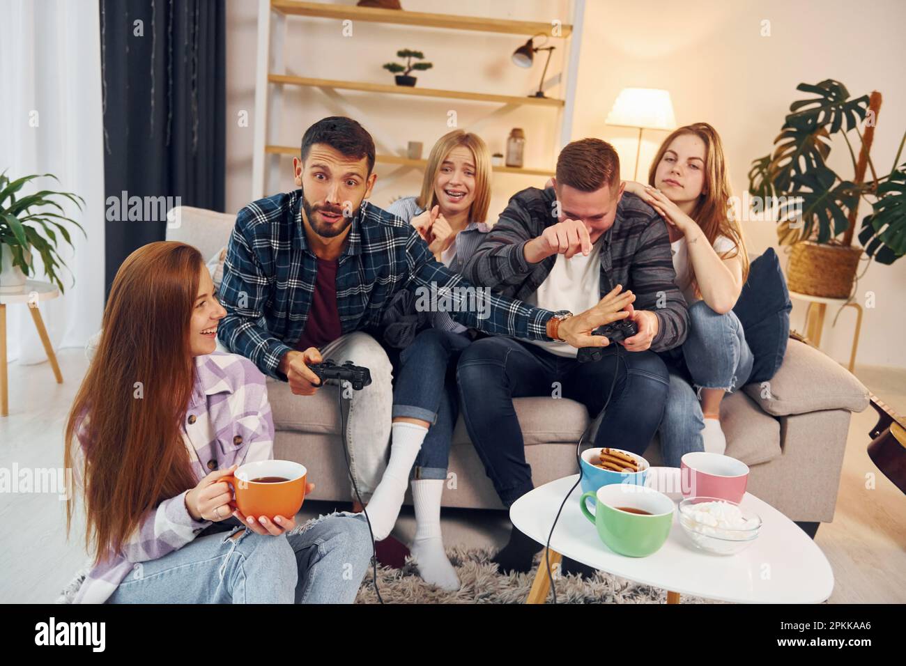 Riproduzione di un videogioco. Gruppo di amici hanno partito insieme all'interno. Foto Stock