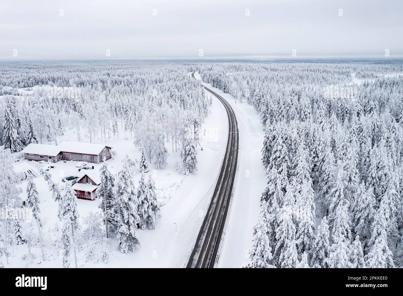 Strada tortuosa che attraversa la foresta innevata ghiacciata, vista aerea, Lapponia, Finlandia, Europa Foto Stock