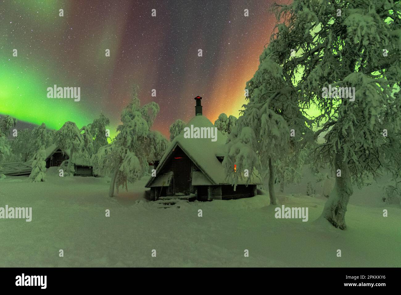 Capanne nel bosco innevato sotto l'aurora boreale (Aurora borealis), Parco Nazionale Pallas-Yllastunturi, Muonio, Lapponia, Finlandia, Europa Foto Stock