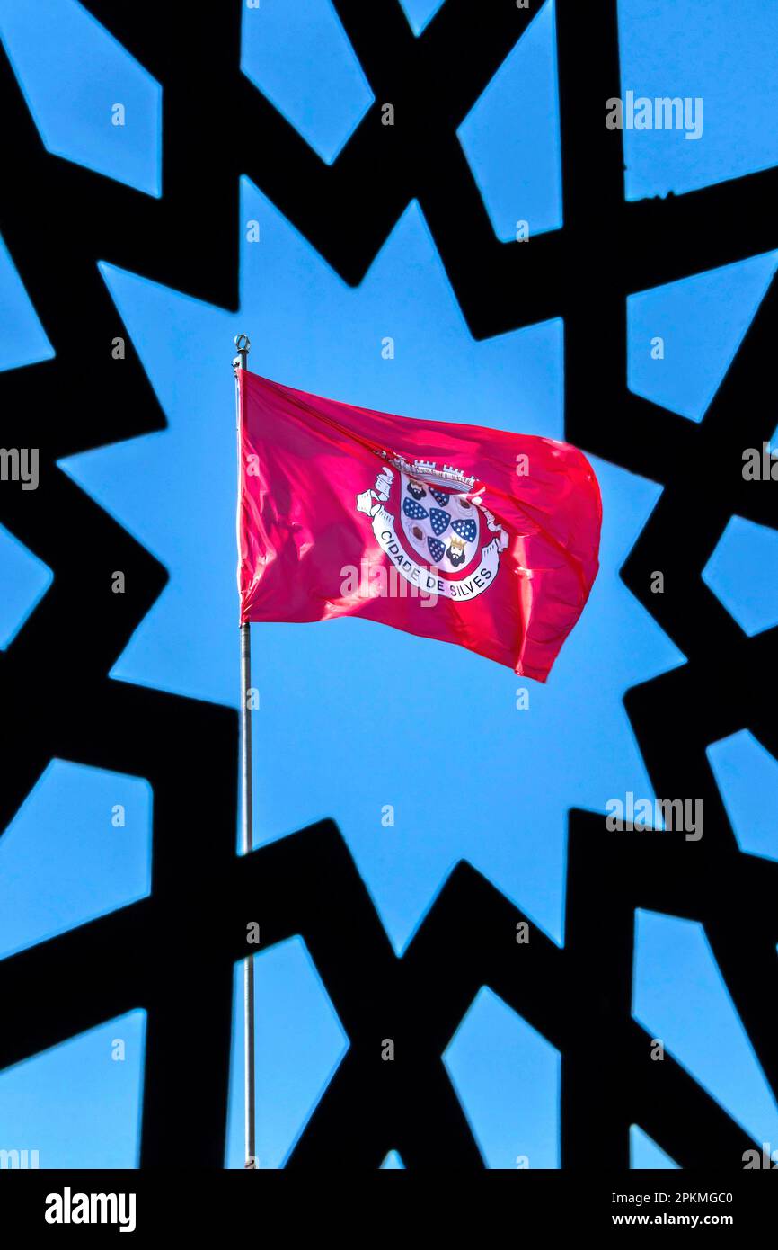 città di silves bandiera contro il cielo blu algarve portogallo vived attraverso una griglia decorativa a forma di stella Foto Stock