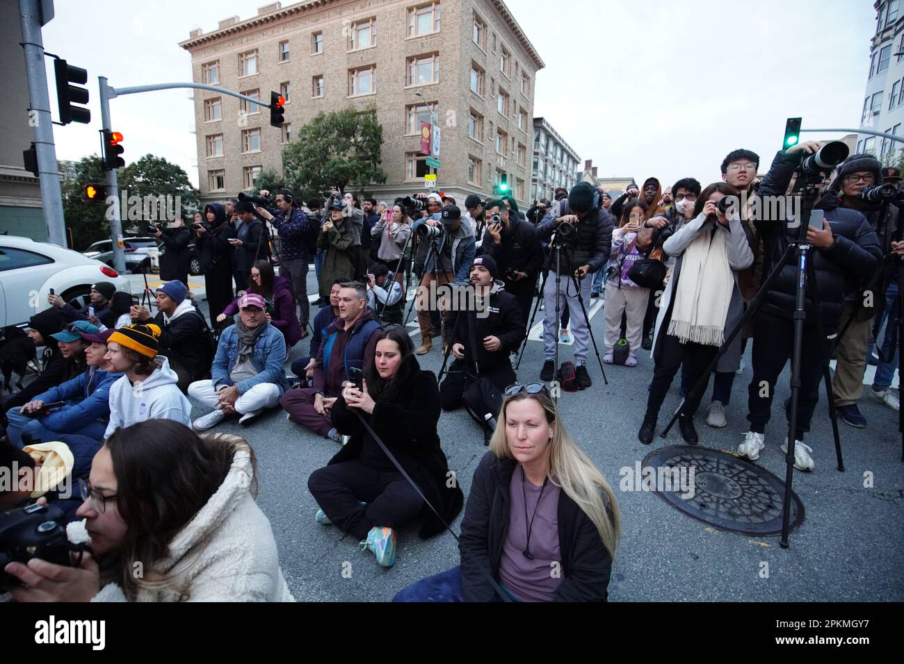 Le persone si riuniscono all'incrocio tra California Street e Gough Street e scattano foto per l'alba. Il sole che sorge si allinea tra California Street e Gough Street a San Francisco. Il sole incornicia gli edifici e sorge sopra il Bay Bridge. Si verifica dal 8 aprile al 10 aprile e si verifica due volte all'anno. Il 8 aprile, centinaia di persone si sono riunite all'incrocio tra California Street e Gough Street. Molti di loro vengono con gli attrezzi di fotografia professionali e scattano le foto dell'alba nel mezzo della strada. Foto Stock