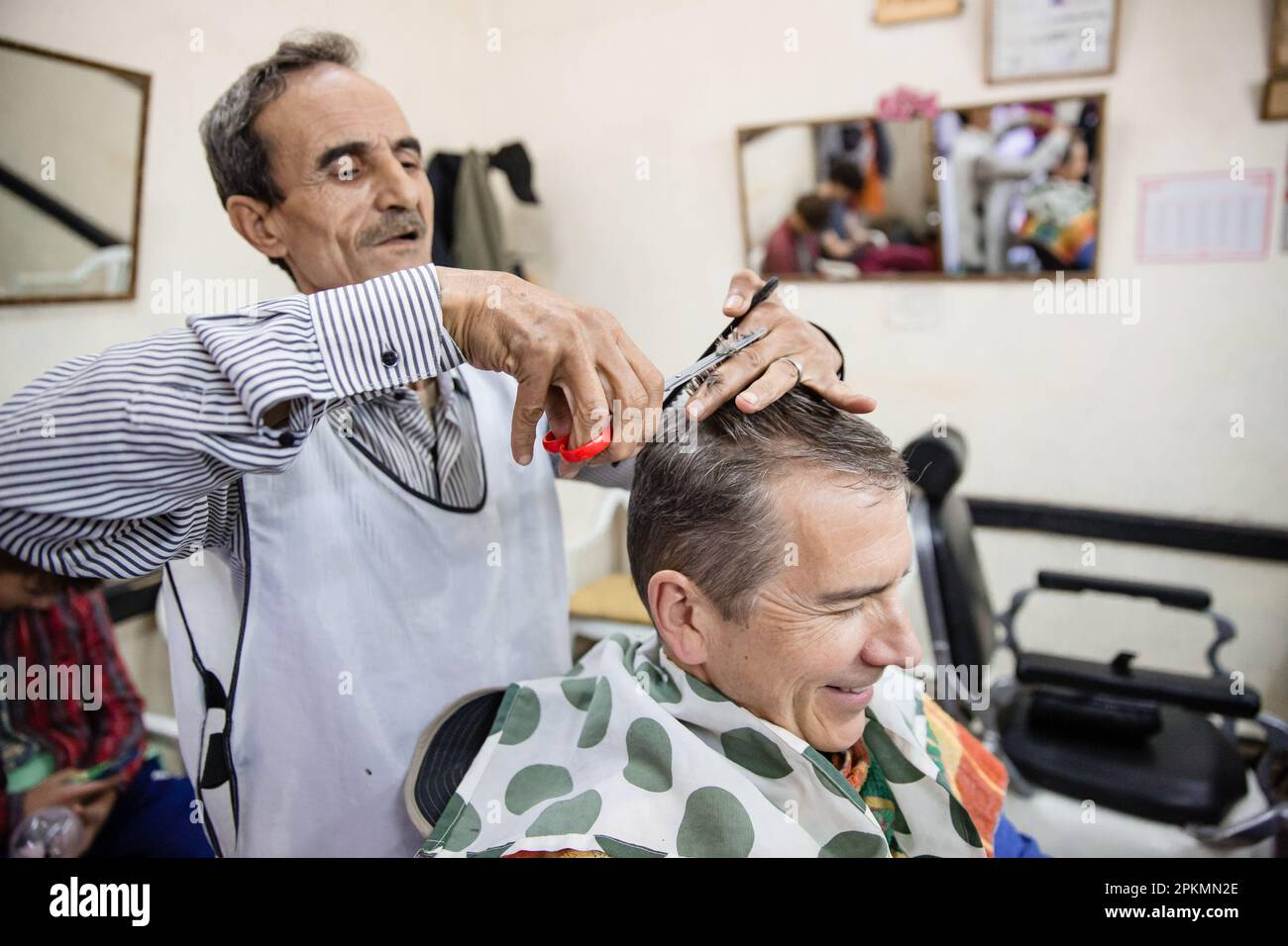 Un turista americano ottenere un taglio di capelli in un barbiere a Marrakech Marocco Foto Stock
