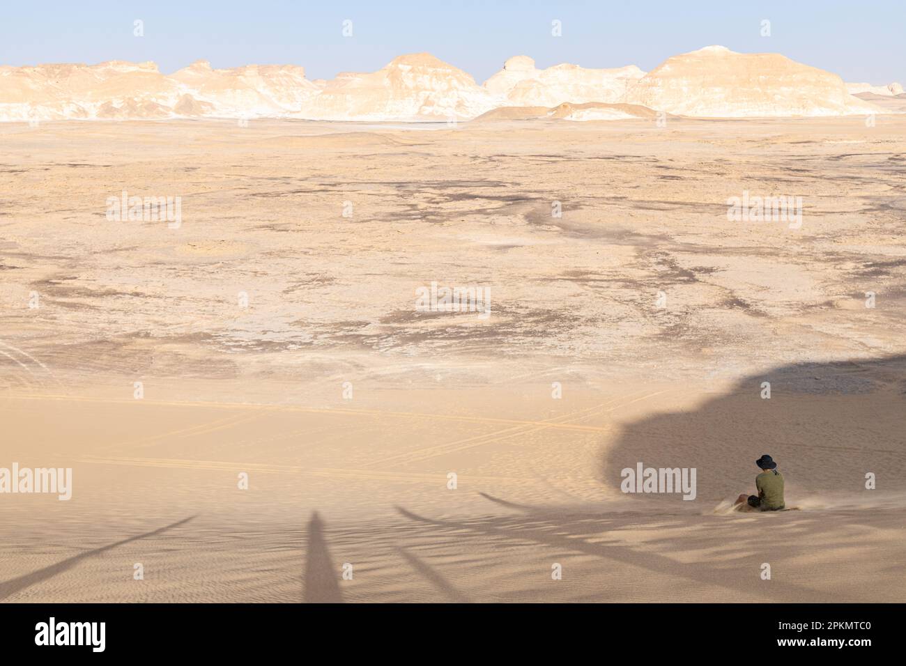 Un sandboarding turistico lungo un pendio in un deserto vicino a Bahariya in Egitto Foto Stock