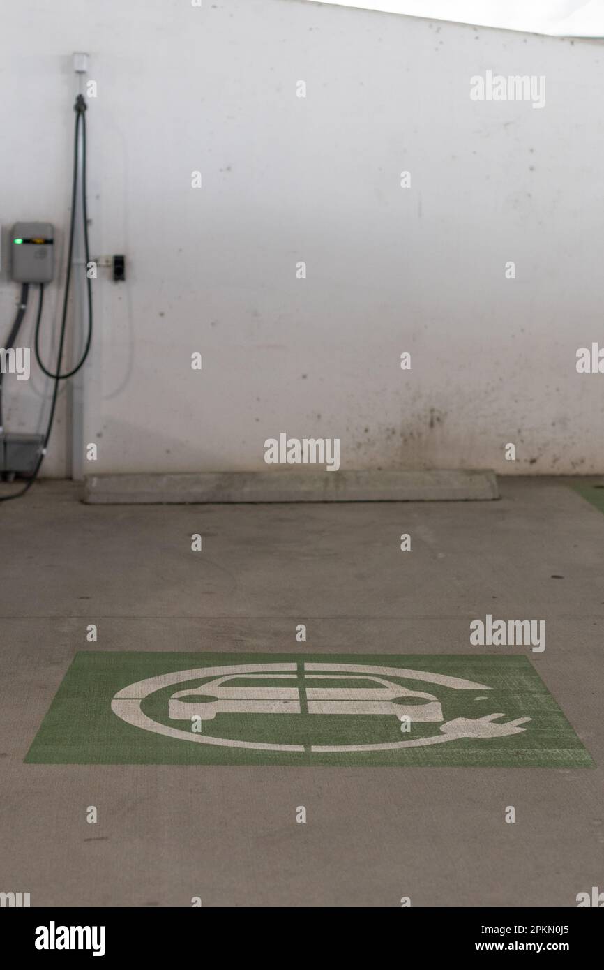 Cartello verde di ricarica per auto elettriche verniciato sul pavimento vicino alla stazione di ricarica per veicoli elettrici. Preso nella zona del lago Nona, Florida. Foto Stock