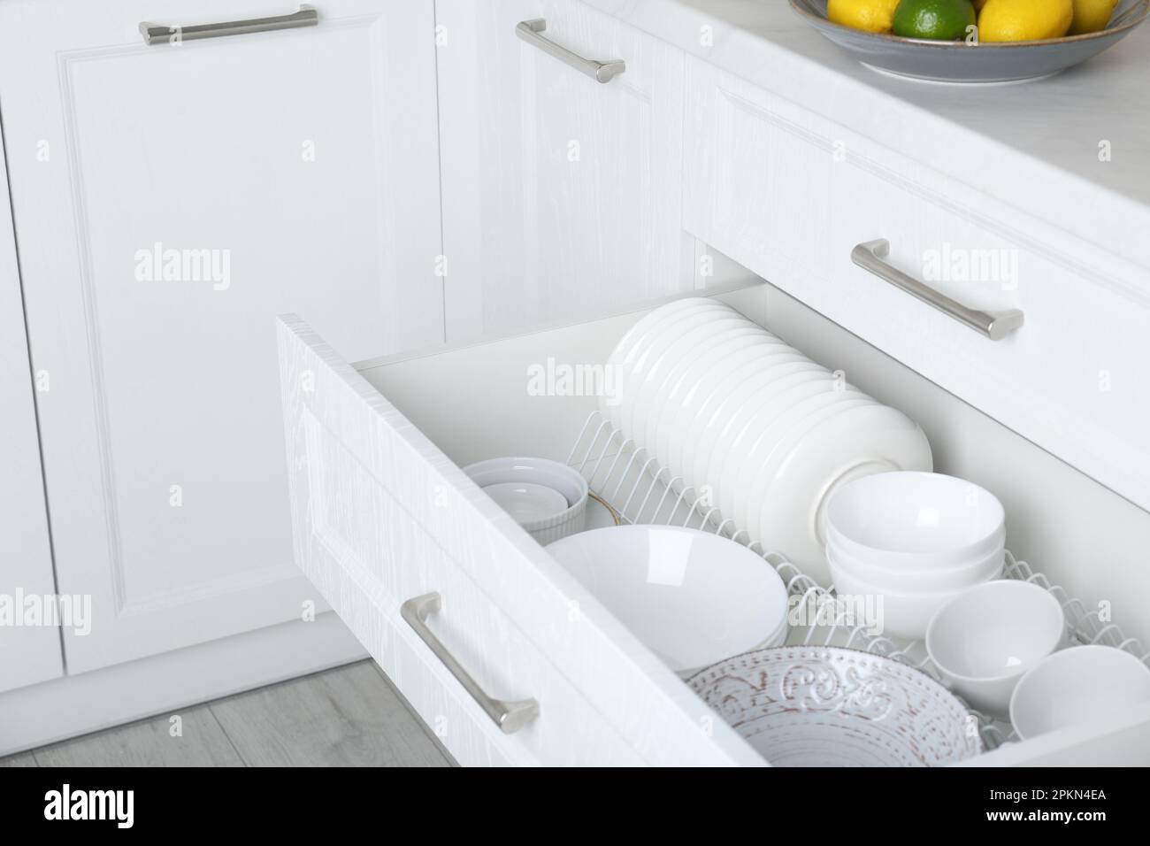 Cassetto aperto con piatti e ciotole diversi in cucina Foto Stock