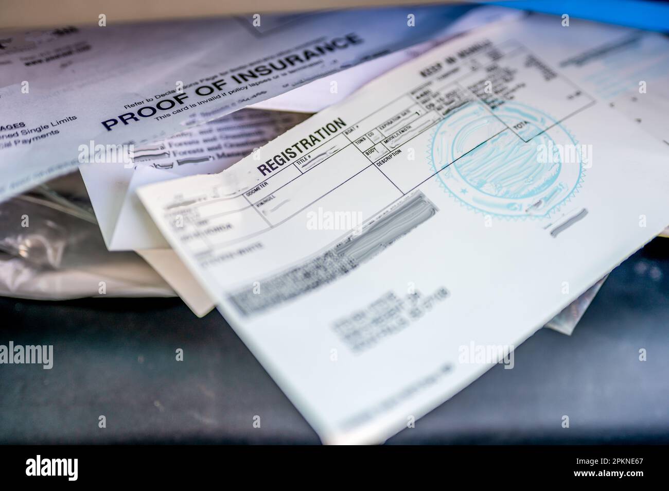 Prova dell'assicurazione e dei documenti di immatricolazione nel vano portaoggetti di un'auto. Foto Stock