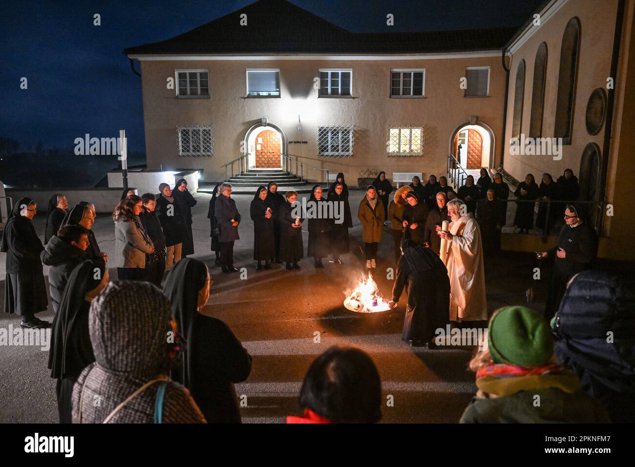 Reute bei Bad Waldsee, Germania. 09th Apr, 2023. Padre Ulrich Steck, superiore del Monastero di Reute, tiene in mano la candela pasquale, illuminata poco dopo da una suora francescana del Monastero di Reute. Le monache francescane di Reute illuminano tradizionalmente il fuoco pasquale nelle prime ore del mattino della domenica di Pasqua. Più di 40 monache e ospiti partecipano all'ora di preghiera. Credit: Felix Kästle/dpa/Alamy Live News Foto Stock