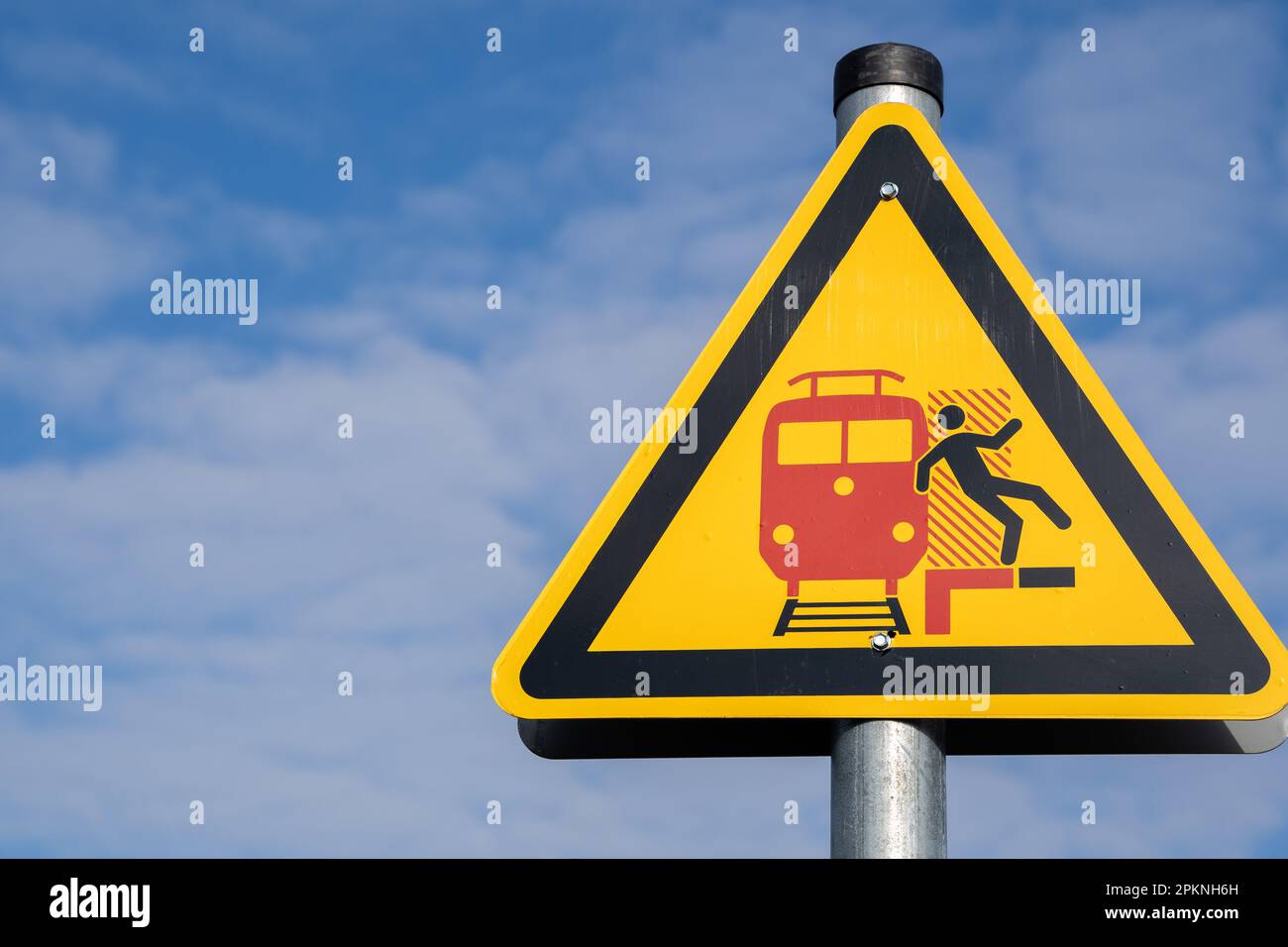 Cartello giallo triangolare su una piattaforma in germania per prestare attenzione al passaggio dei treni e non si verificano incidenti Foto Stock