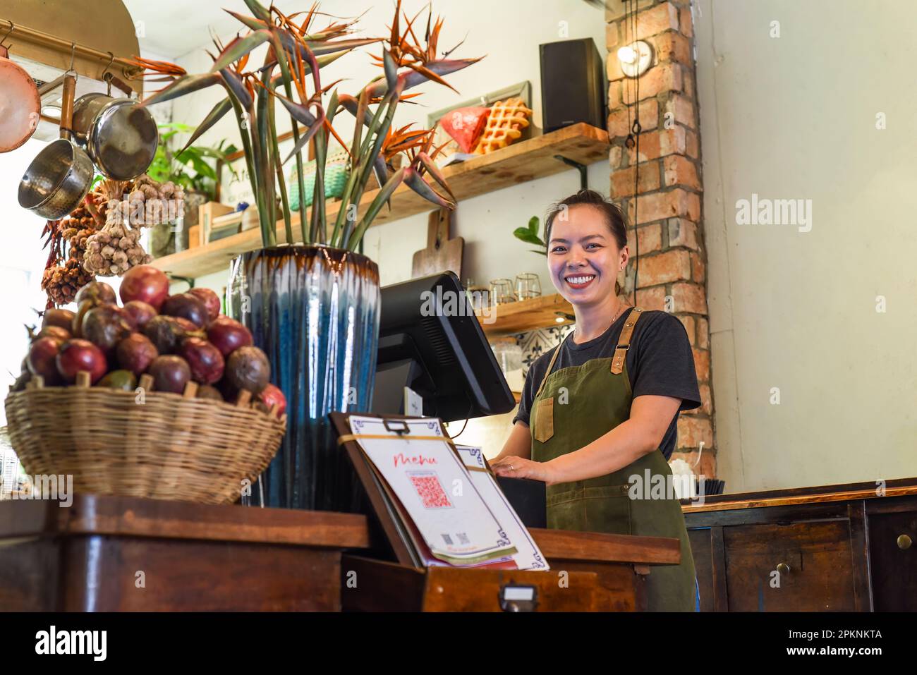 Cameriera felice vietnamita che lavora in una cucina di un caffè Foto Stock