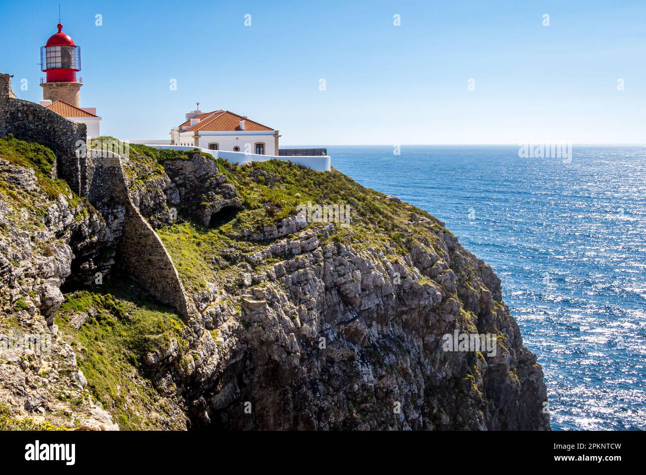 Arroccato in cima a una rupe frastagliata del promontorio di Cabo de São Vicente, lo storico e spettacolare faro Farol do Cabo de São Vicente sorge in alto. Foto Stock