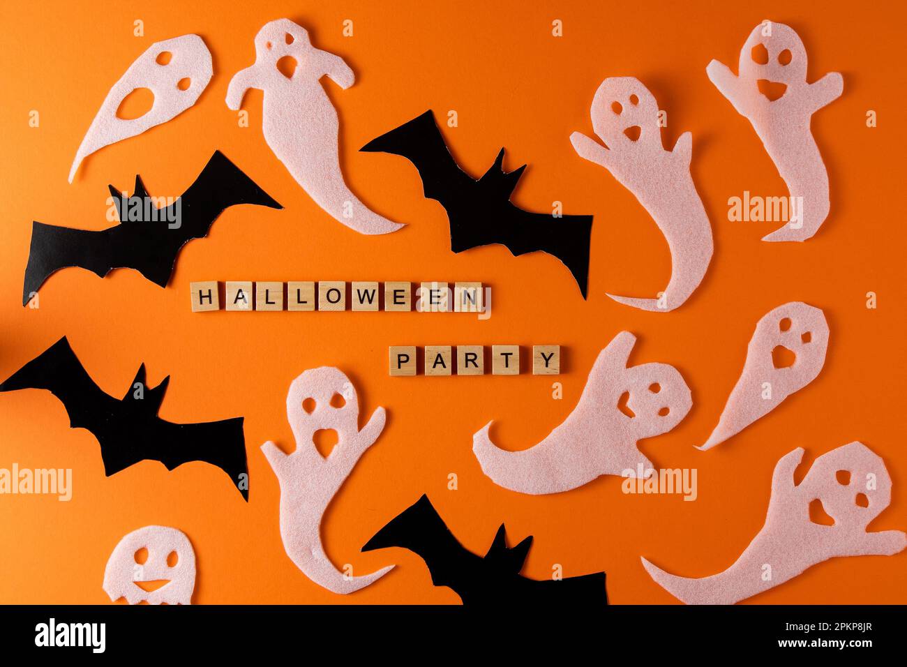 Fantasmi bianchi e mazza per la festa di Halloween. Immagine fantasma della carta di avvolgimento su sfondo arancione vista dall'alto. Fumetto Creepy Whisper. Fai-da-te fatto a mano. Impostare i caratteri boo. Parola frase di legno della lettera. Foto Stock
