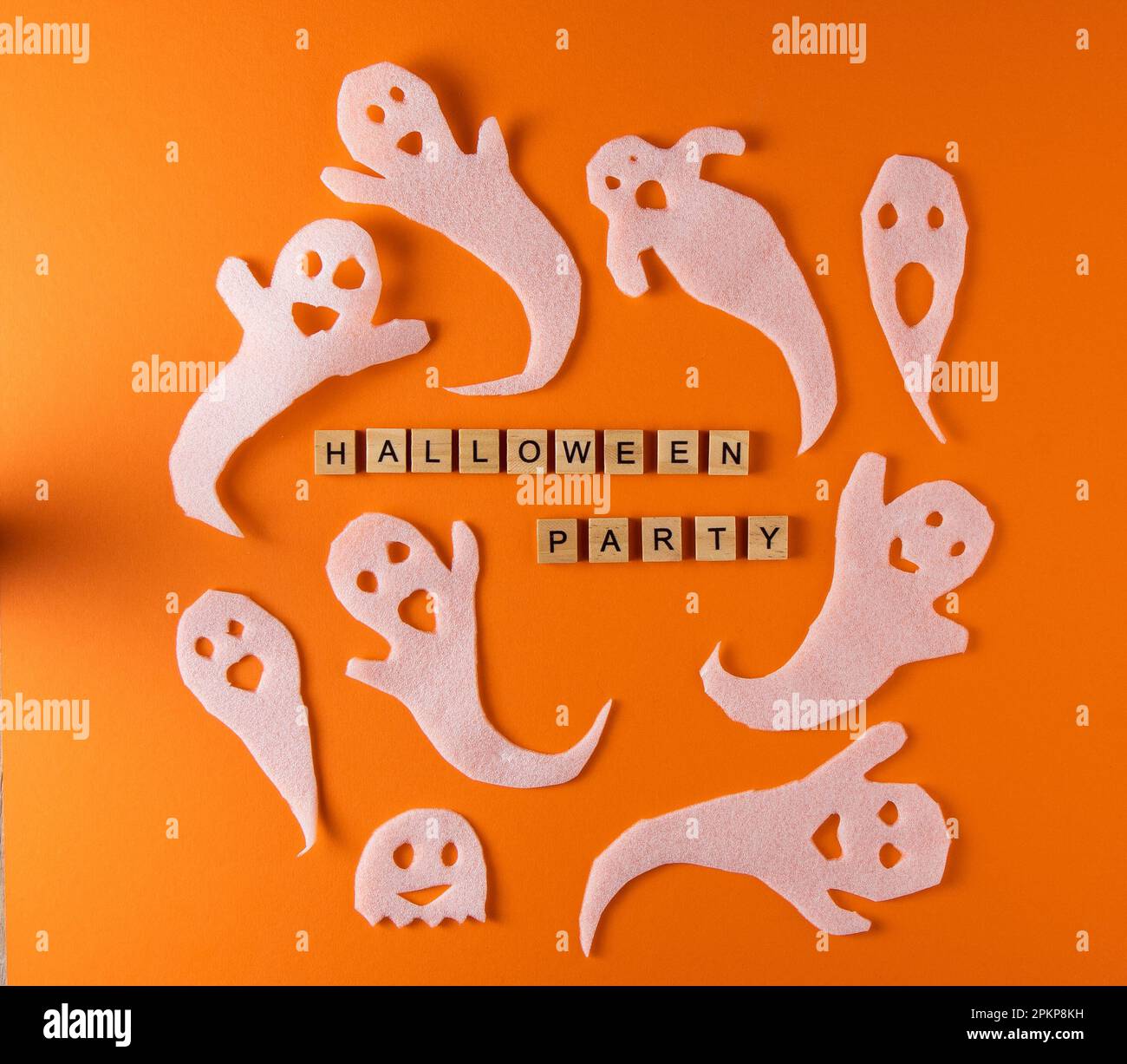 Fantasmi bianchi per la festa di Halloween. Immagine fantasma della carta di avvolgimento su sfondo arancione vista dall'alto. Fumetto Creepy Whisper. Fai-da-te fatto a mano. Impostare i caratteri boo. Parola frase di legno della lettera. Foto Stock
