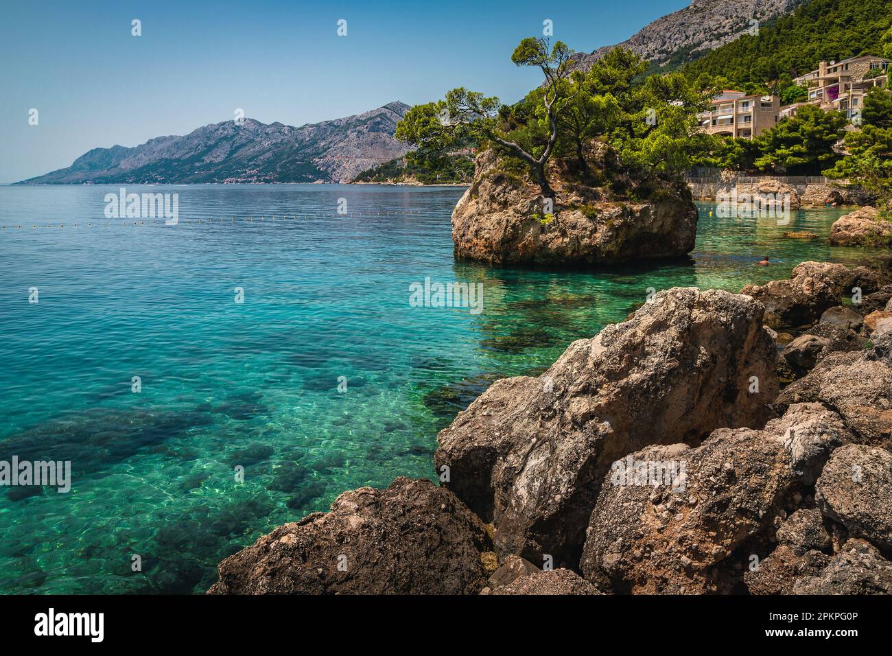 Pittoresco scenario naturale con mare pulito e unica isola rocciosa nel mare Adriatico. Una delle più belle spiagge della Dalmazia, Brela, Makarska riv Foto Stock