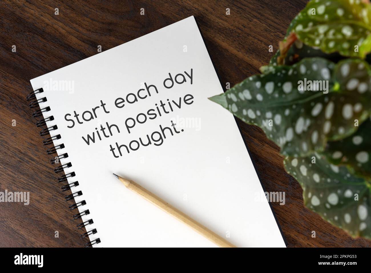 Blocco note con testo - inizia ogni giorno con un pensiero positivo Foto Stock